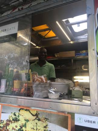 Dishing it out at the vendys Godshelter Oluwalogbon inside his food truck. Photo: Carson Kessler