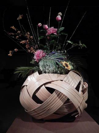 Weaving a Tale "Dragon in the Clouds Flower Basket" by Iizuka Shokansai holds an ikebana floral display created by the Ikebana International New York Chapter. Photo: Adel Gorgy
