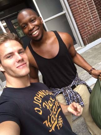 From the Gym to Chiang Rai: The Fitness Model Activists Building for Better founder and CEO Michael Dean Johnson with a Chelsea resident. Photo: Kevin Sowyrda