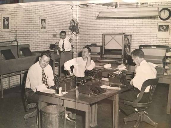 ‘TOO TOUGH TO DIE’ No, it’s not the set of a movie, it’s the City Room of the Daily News in the early 1950s, complete with pencil sharpeners and manual typewriters. At rear (pointing) is longtime press agent, publicist and political fixer Morty Matz, then an assistant picture assignment editor at The News. Photo: Collection of Morty Matz