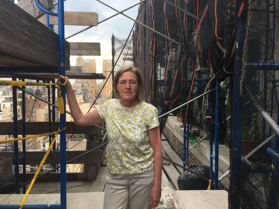 it's neighbor against neighbor on 71st street news Susan Schwartz on the balcony of a friend's penthouse apartment in the building, with scaffolding and construction in the background. Photo by Madeleine Thompson