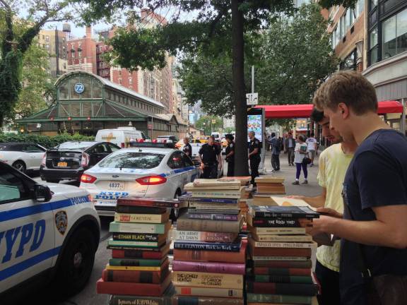 Throwing the Book at a Broadway fixture News Police officers confer steps from Kirk Davidson's sidewalk book table on Broadway near 73rd Street on July 13, a week after police dismantled several similar tables and impounded thousands of books along that stretch of the avenue. Photo: Richard Khavkine