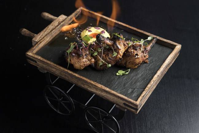 Not Your Neighborhood Indian Restaurant Flaming chicken chops served on a cart. Photo: Evan Sung