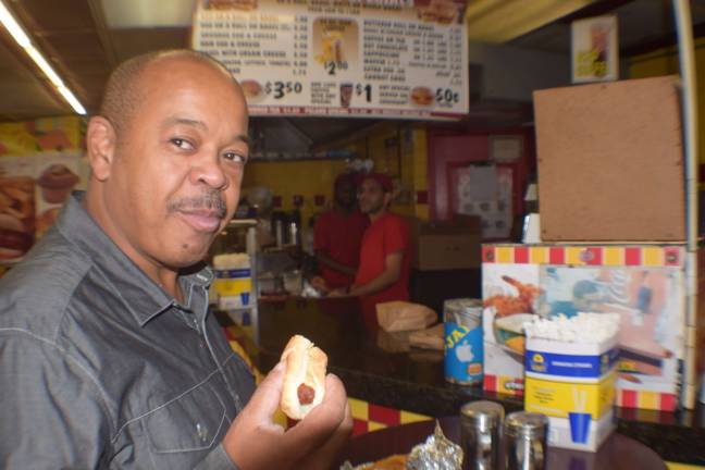 On 23rd street, community responds Finnis Smithwick enjoys a hot dog at Chelsea Papaya. Photo: Genia Gould