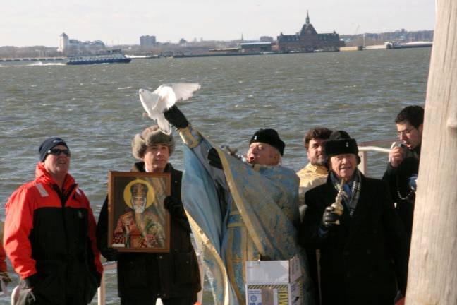 Iconic Greek Priest at WTC church dies Father John Romas releases a dove at the conclusion of the annual Greek Orthodox 'Blessing Of The Waters/Diving For The Cross' at Battery Park. Photo: Joseph M. Calisi