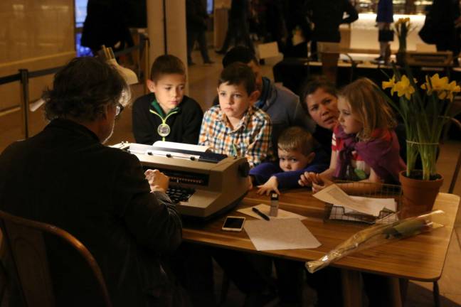 the lyrical everyday Poet Bob Holman writes a poem for a group of children at the Poetry in Motion event at Grand Central Terminal. Photo: Katherine Warren