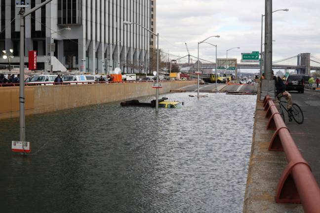 THREATENING OUR CITY’S FUTURE Hurricane Sandy flooding at Battery Park underpass: Photo: Timothy Krause, via flickr