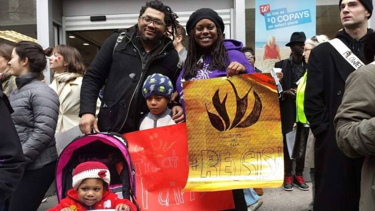 Onward: 400,000 take to the streets Deva Woodly, an assistant professor of politics at the New School , with her family at Saturday's Women's March in New York. “It's up to the people now – we're the last check," she said. "My kids will need to keep fighting.” Photo: Charmaine P. Rice