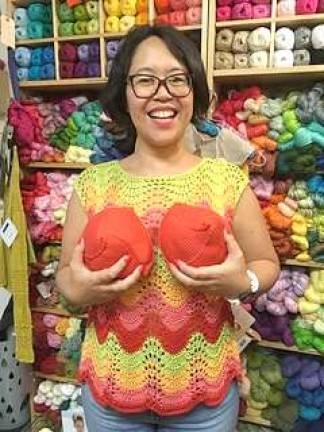 Knitty City employee Nancy Ricci with orange knitted knockers. LatinaSHARE asked for larger, brightly colored inserts. Photo: Leslie Gersing