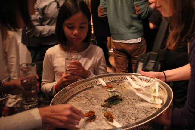 Alexa Saur, 9, contemplates a &quot;Thai cricket spoon,&quot; with lemongrass, carrot, cilantro and, of course, crickets.&#160;Alexa was partaking in the first ingredient featured at the &quot;Crickets and Cocktails&quot; event at the Explorers Club on Saturday, Nov. 21. Photo: Nomin Ujiyediin.