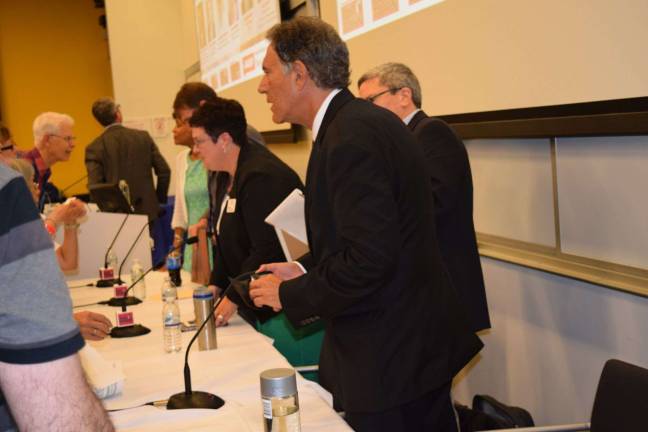 Panelists talking to audience members after the event.